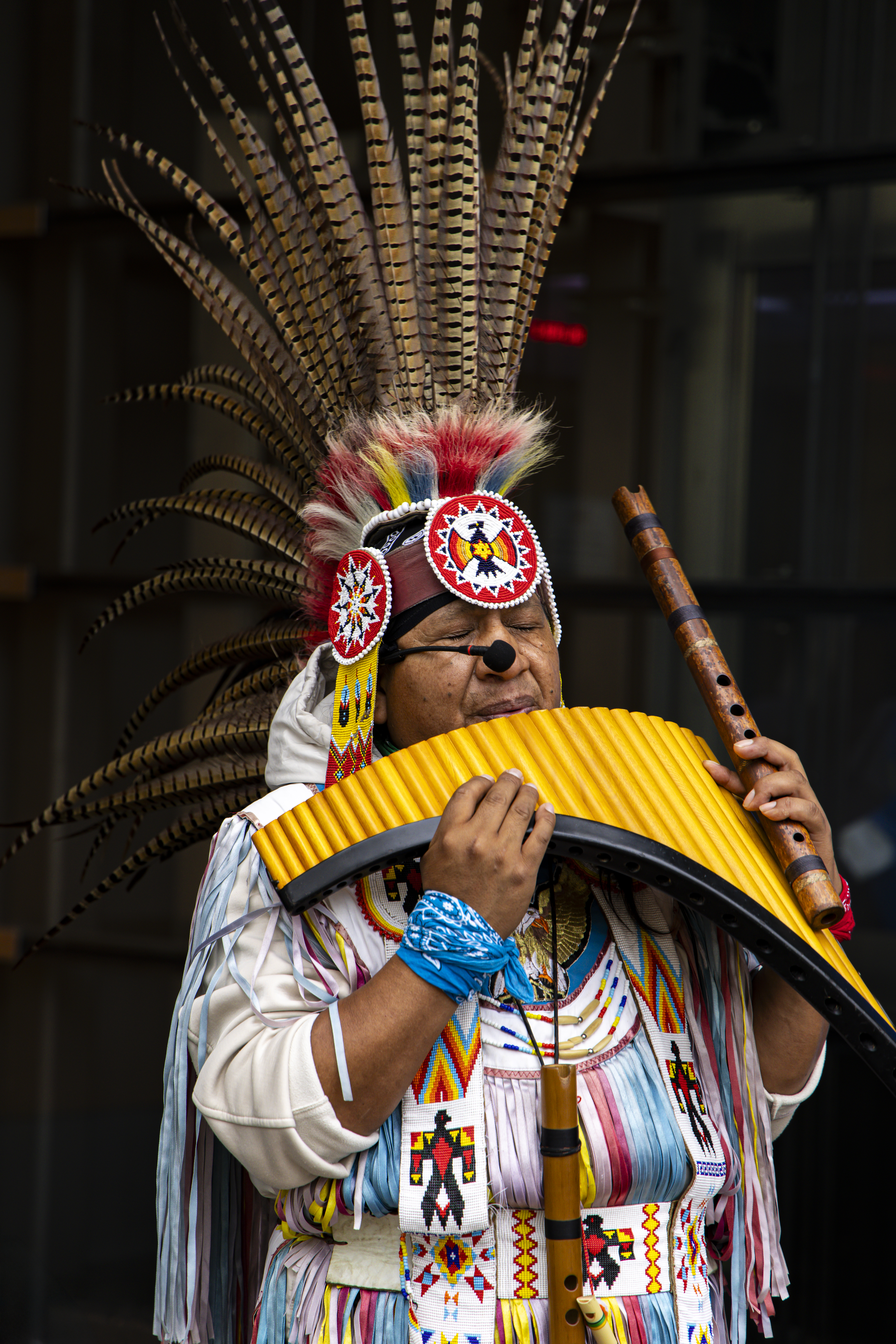 Portrait eines indigenen Flötenspielers mit Federschmuck